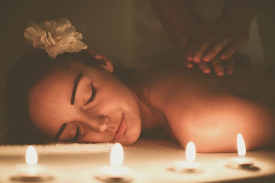 A woman laying down with candles in front of her.