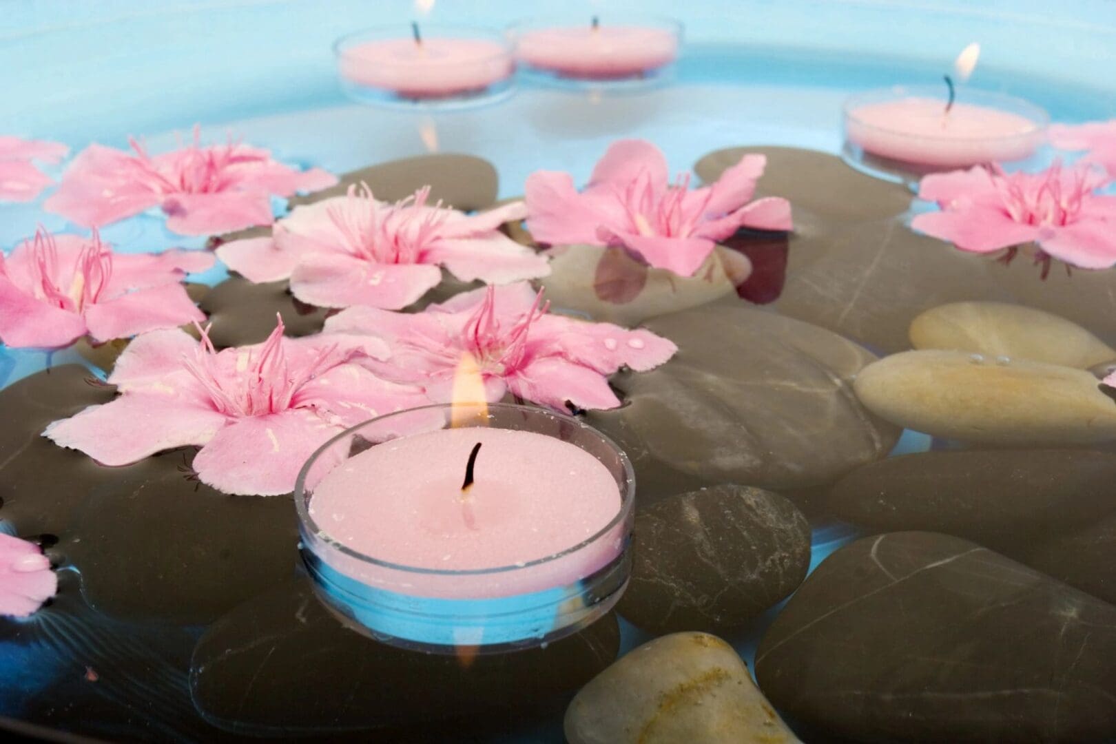 A candle and some flowers in water