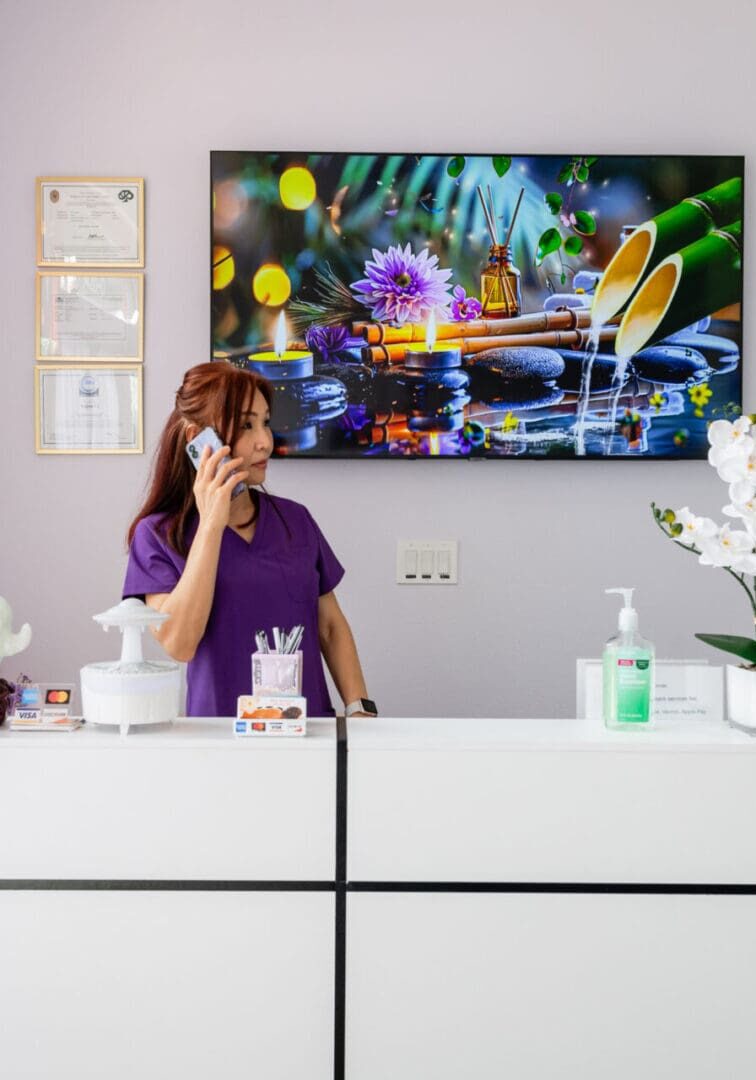 A woman is standing at the reception desk